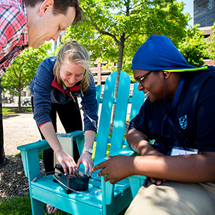 Students surrounding blue chair
