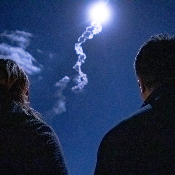 two people watching a space launch