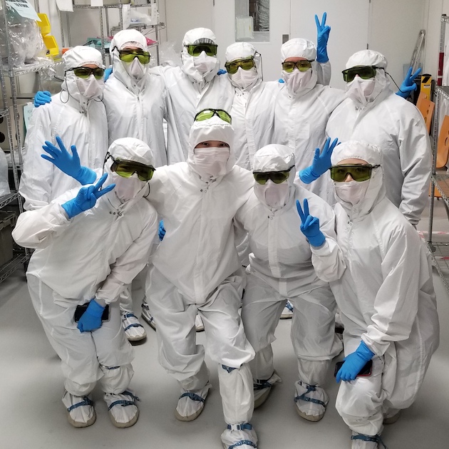 Lurie Nanofabrication Lab group photo of 10 people in a clean room wearing suits