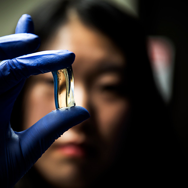 Researcher holds a small block of a gelatin-like material between her fingers