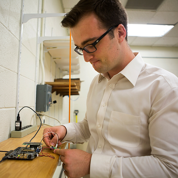Student connecting the wires of a circuitboard